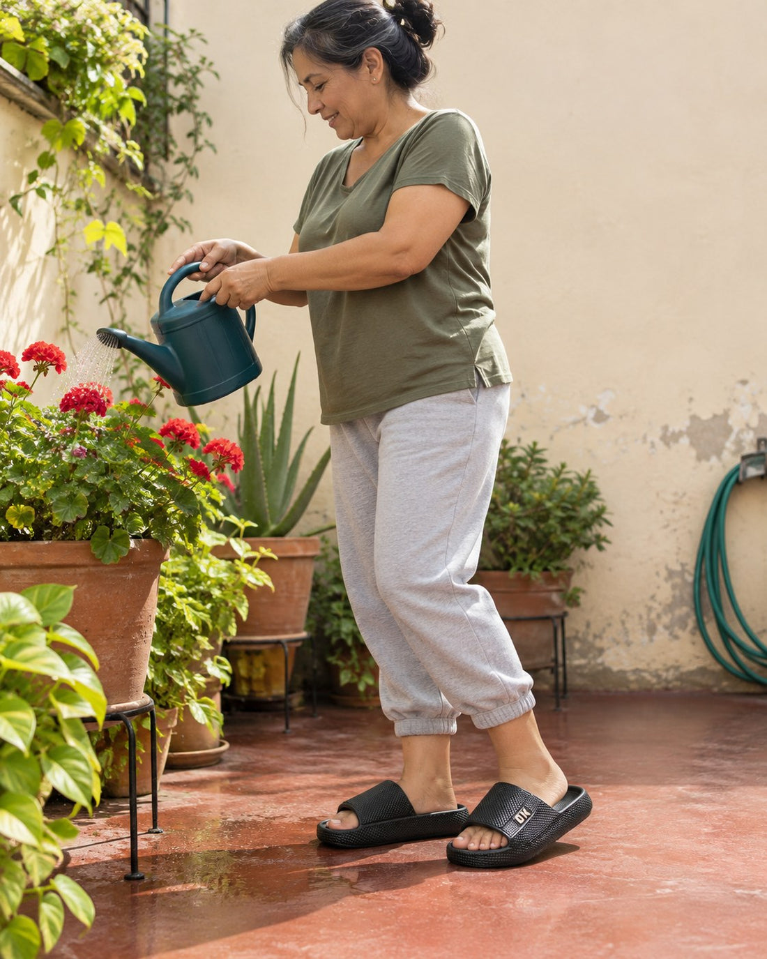 Señora regando plantas con Sandalias OK negras